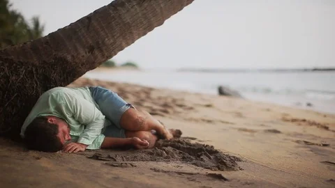 Disappointed depressed lost man coming to life and getting up. Desert island. Stock Footage 80437868