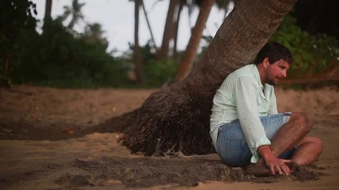 Disappointed depressed lost man sitting and thinking about life. Desert island. Stock Footage 80446986