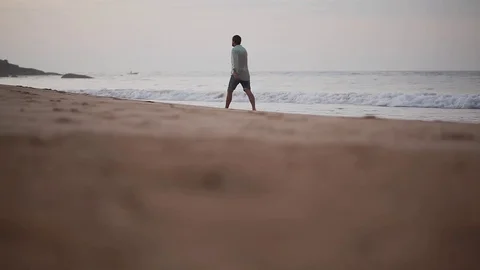 Disappointed depressed man going away by the sea shore Stock Footage 80423495