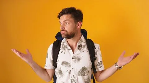Disappointed face expression on young bearded traveler with backpack isolated Stock Photos