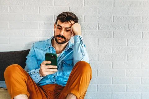 A disappointed man checking his smartphone, online problems, bad news, digi.. Fotos de archivo