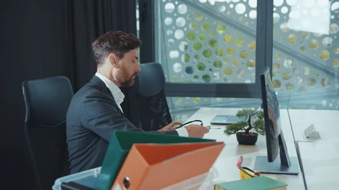 Disappointed man office worker packing a box with office stuff from his table Stock Footage 130002261