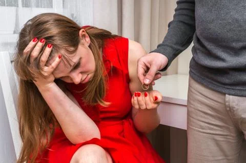 Disappointed man returning wedding ring to his wife - divorce concept Stock Photos
