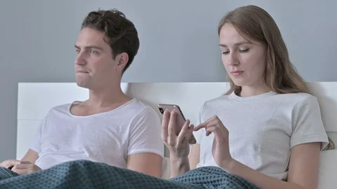 Disappointed Man Sitting with Couple while she Uses Smartphone Stock Footage 118669088