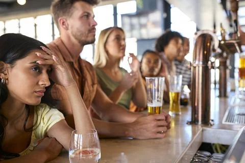 Disappointed Multi-Cultural Group Of Friends In Sports Bar Watching Team Lose Stock Photos