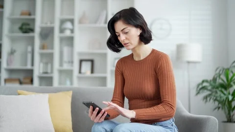 Disappointed woman complains about poor performance of program on smartphone  Vidéo 285431553