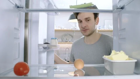 Disappointed young man opens his fridge to find it empty. POV inside fridge Stock Footage
