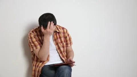 Disappointed young man using a pad Stock Footage 60064285
