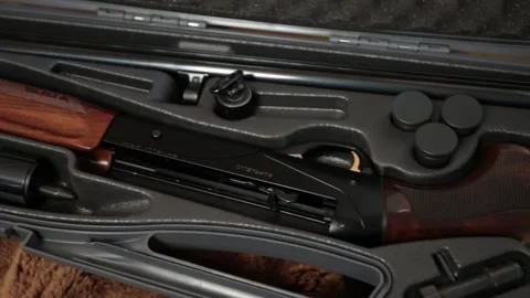 A disassembled 12 gauge hunting shotgun in a gray gun case Stock Footage