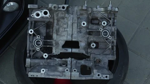 Disassembled aluminum car engine block casting on top of tire. Stock Footage 341137204