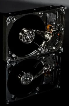 Disassembled and opened hard disk drive, inside view with reflections, isolat Foto stock