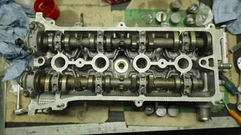 Disassembled car engine cylinder head with camshafts on a workbench Stock Footage 340334888
