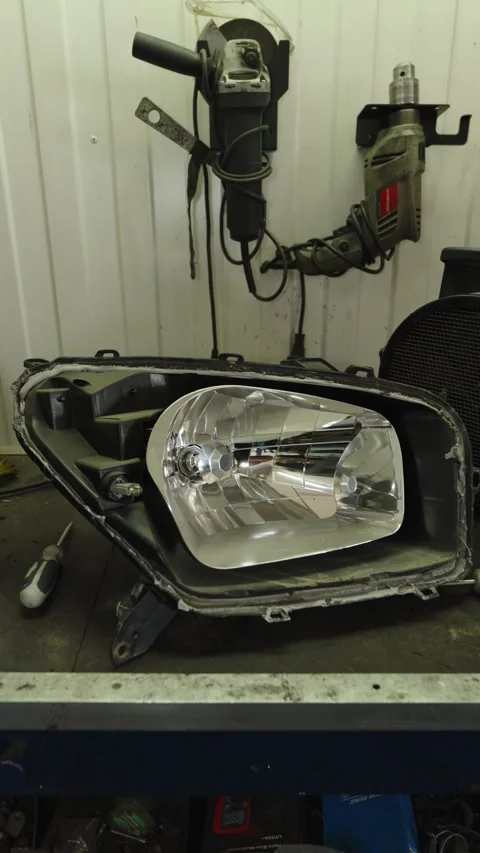 A disassembled car headlight showing the inner chrome reflector housing Stock Footage 339684190