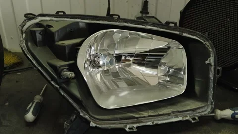 A disassembled car headlight showing the inner chrome reflector housing Stock Footage 339684222