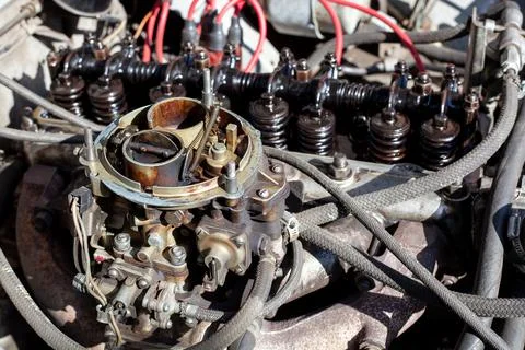 Disassembled carburetor on old engine without top and air filter. Carburettor Stock Photos