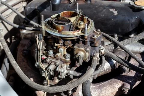 Disassembled carburetor on old engine without top and air filter. Carburettor Stock Photos