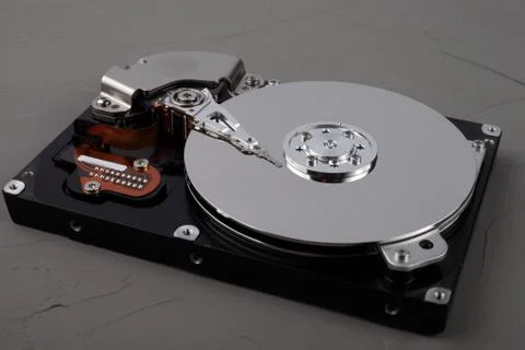 Disassembled computer hard drive with mirror disks on concrete background Foto stock