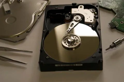Disassembled computer hard drive on the table next to the instrument Stock Photos