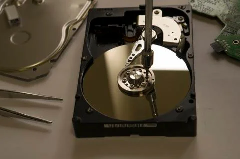 Disassembled computer hard drive on the table next to the instrument Stock Photos