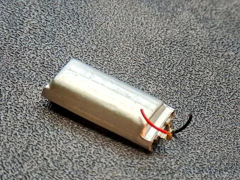 Disassembled cylindrical component with attached wires rests on textured ba.. Stock Photos