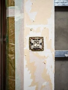 Disassembled electrical switch on wall of room Stock Photos
