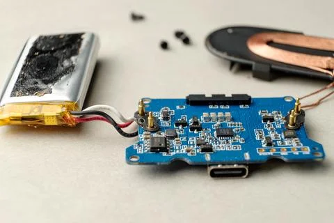Disassembled electronic circuit board showcasing battery and components Stock Photos