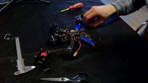 Disassembled FPV quadrocopter, do-it-yourself drone repair on a black table Stock Footage 168279029