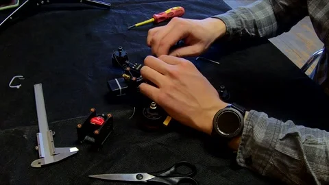 Disassembled FPV quadrocopter, do-it-yourself drone repair on a black table Stock Footage 168279045