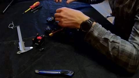 Disassembled FPV quadrocopter, do-it-yourself drone repair on a black table Stock Footage 168279063
