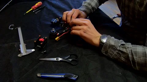 Disassembled FPV quadrocopter, do-it-yourself drone repair on a black table Stock Footage 168279076