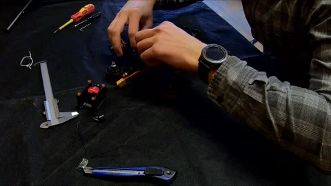 Disassembled FPV quadrocopter, do-it-yourself drone repair on a black table Stock Footage 168279102