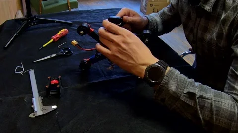 Disassembled FPV quadrocopter, do-it-yourself drone repair on a black table Stock Footage 168279116