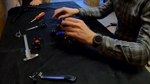 Disassembled FPV quadrocopter, do-it-yourself drone repair on a black table Stock Footage 168279196