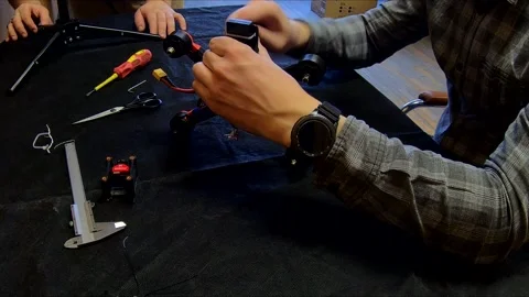 Disassembled FPV quadrocopter, do-it-yourself drone repair on a black table Stock Footage 168279203
