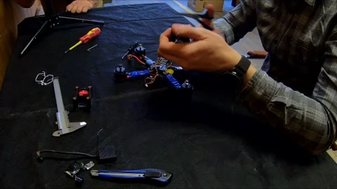 Disassembled FPV quadrocopter, do-it-yourself drone repair on a black table Stock Footage 168279278