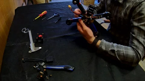 Disassembled FPV quadrocopter, do-it-yourself drone repair on a black table Stock Footage 168279324