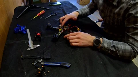 Disassembled FPV quadrocopter, do-it-yourself drone repair on a black table Stock Footage 168279454