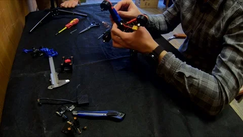 Disassembled FPV quadrocopter, do-it-yourself drone repair on a black table Stock Footage 168279464