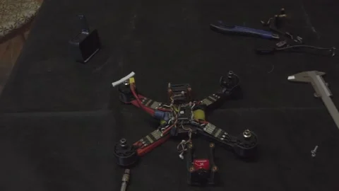 Disassembled FPV quadrocopter, do-it-yourself drone repair on a black table Stock Footage 168279504