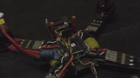 Disassembled FPV quadrocopter, do-it-yourself drone repair on a black table Stock Footage 168279517