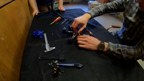 Disassembled FPV quadrocopter, do-it-yourself drone repair on a black table Stock Footage 168279572