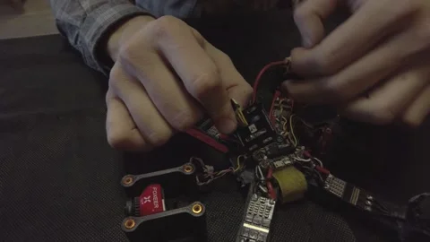 Disassembled FPV quadrocopter, do-it-yourself drone repair on a black table Stock Footage 168279686