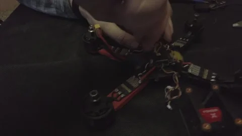 Disassembled FPV quadrocopter, do-it-yourself drone repair on a black table Stock Footage 168279712