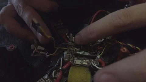 Disassembled FPV quadrocopter, do-it-yourself drone repair on a black table Stock Footage 168279768