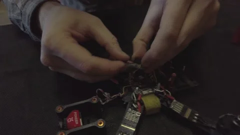 Disassembled FPV quadrocopter, do-it-yourself drone repair on a black table Stock Footage 168279780