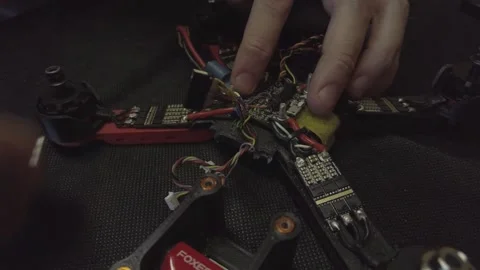Disassembled FPV quadrocopter, do-it-yourself drone repair on a black table Stock Footage 168279897