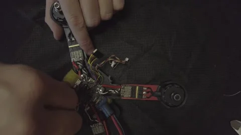 Disassembled FPV quadrocopter, do-it-yourself drone repair on a black table Stock Footage 168279907