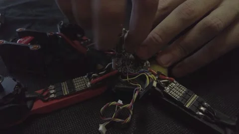Disassembled FPV quadrocopter, do-it-yourself drone repair on a black table Stock Footage 168279939