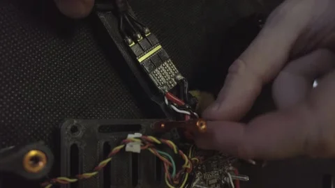 Disassembled FPV quadrocopter, do-it-yourself drone repair on a black table Stock Footage 168280175