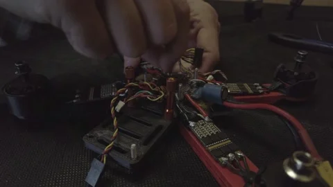 Disassembled FPV quadrocopter, do-it-yourself drone repair on a black table Stock Footage 168280231
